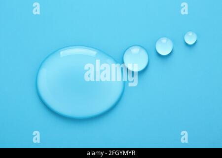 Water drops in shape of Thought bubble on blue background. Stock Photo