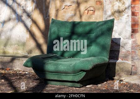 old green sofa on the street in the city. High quality photo Stock Photo