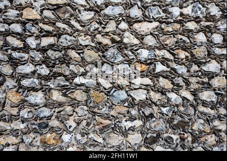 Front flat view of a flint wall on an old church building. For use as a random pattern on wallpaper or other abstract or background applications. Stock Photo