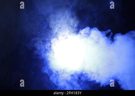 Smoke in blue light on black background Stock Photo