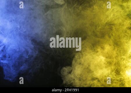 Smoke in blue yellow light on black background Stock Photo