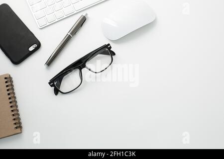 Office workplace with keyboard, notepad, glasses telephone and pen on white background Stock Photo