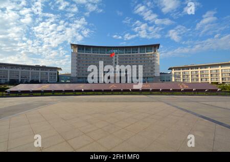 Main building of the Jiaxing People's Government offices. Red national flag flying in front of the entrance. Stock Photo