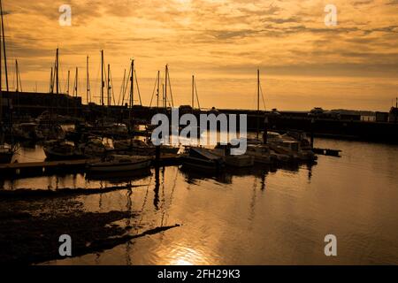 Boats and yachts moored at Victoria Dock Marina at sunset in Caernarfon, Wales Stock Photo