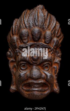 Traditional cast-iron mask of Mahakala, Great Time god, old and rusty, isolated on black background Stock Photo