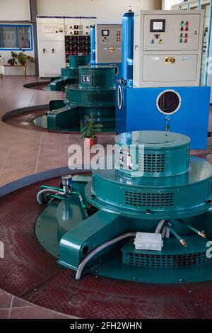 Almaty reg., Kazakhstan:Hydroelectric power plant machine room.Green electric generators.Power cabinets.Control panels,indicator lamps,switchers. Stock Photo