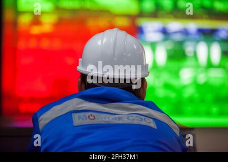 Moinak hydroelectric power station operator watching on screen. Controlling processes. Man in focus, screen blurred. Stock Photo