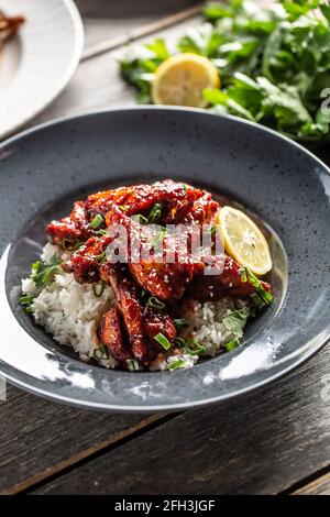 Asian style honey glazed chicken, coriander leaves, rice and lemon. Stock Photo