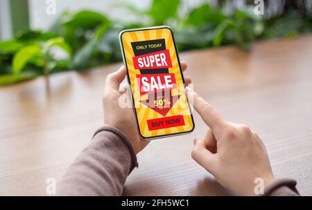 Female finger clicking on super sale offer on smartphone screen Stock Photo