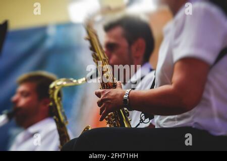 Concert view of an jazz orchestra tubist Tuba player performs with musical jazz band and audience in the background on open air concert Stock Photo