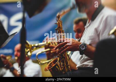 Concert view of an jazz orchestra tubist Tuba player performs with musical jazz band and audience in the background on open air concert Stock Photo