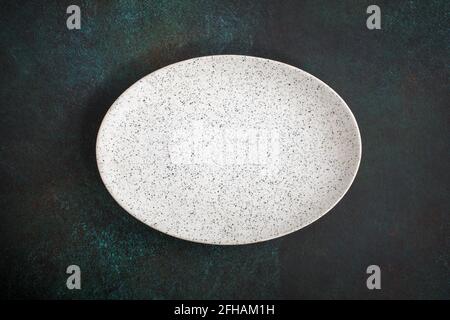 Empty oval plate on dark concrete background. Top view, with copy space Stock Photo