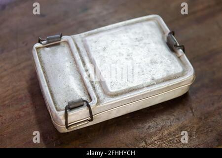 Closeup old and rusty aluminium lunch box on wooden table, old fashion vintage retro style Stock Photo