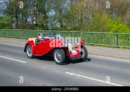 1947 40s MG red 1250cc roadster; moving vehicles, cars, vehicle driving,  roads, motors, motoring, UK road network. Stock Photo