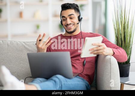 Positive arab guy attending online training from home Stock Photo