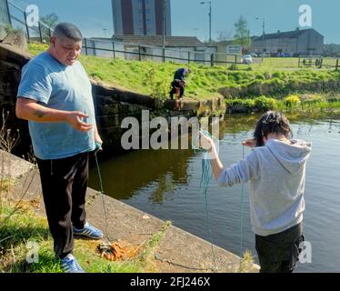 Glasgow, Scotland, UK. 25th April, 2021. UK  Weather:  Sunny with end to lockdown in sight brought the people out on the forth and clyde canal it is now allowed to magnet fishing after the board decided yesterday to allow it and locals at the drumchapel entrance discovered it was full of doubtful treasures . Credit: Gerard Ferry/Alamy Live News Stock Photo