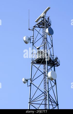 tower with coastal surveillance radar system and various communication equipment on a blue sky background Stock Photo