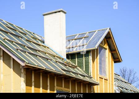 a fragment of a new building of a small simple wooden house on a blue sky background Stock Photo