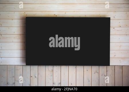 Big turned off TV on wooden wall Stock Photo