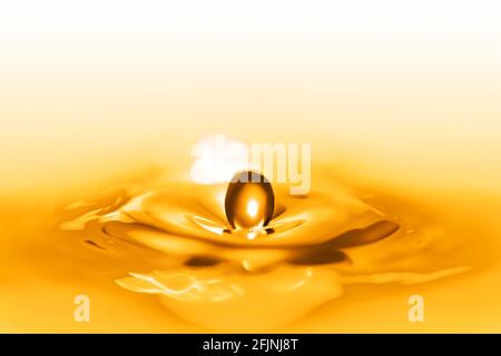 Closeup on drop of water falling in a blue liquid. Stock Photo