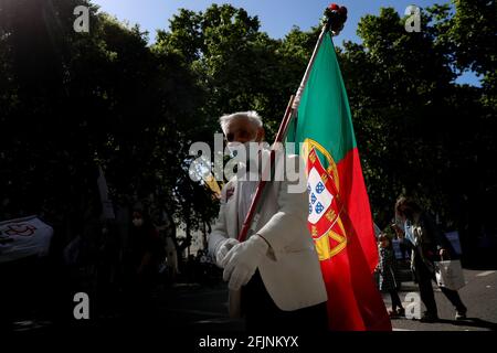 Lisbon, Portugal. 25th Apr, 2021. People wearing face masks take part in a parade to mark the 47th anniversary of the Carnation Revolution amid the COVID-19 pandemic in Lisbon, Portugal, on April 25, 2021. Credit: Pedro Fiuza/ZUMA Wire/Alamy Live News Stock Photo