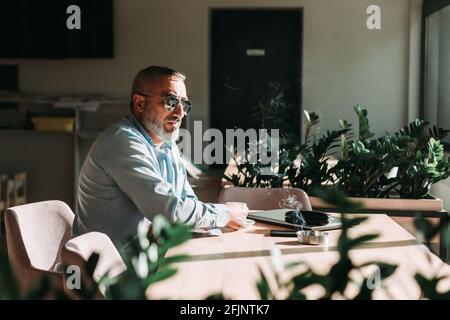 Middle aged bearded man drinking a first morning coffee. Business people Stock Photo