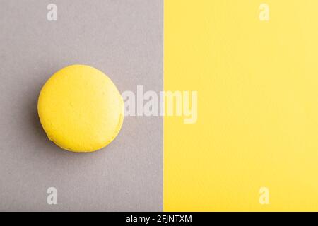 Yellow macaroon on trendy gray and yellow background. top view, flat lay, copy space, close up, still life. Minimalism, morning, contrast concept. Stock Photo