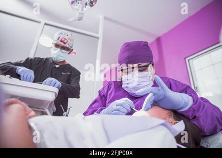 A Mexican female dentist doing dental treatment on a young girl Stock Photo