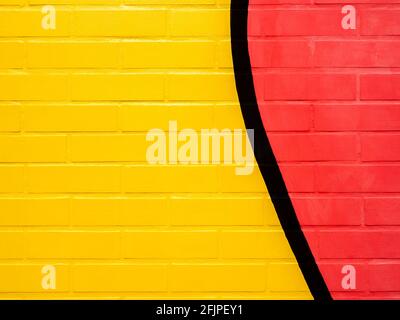 Yellow and red painted brick wall background. Empty space on vivid color brick wall texture. Stock Photo