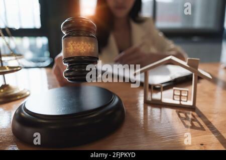 Business woman and lawyers discussing contract papers with brass scale on wooden desk in office. Law, legal services, advice, Justice and real estate Stock Photo