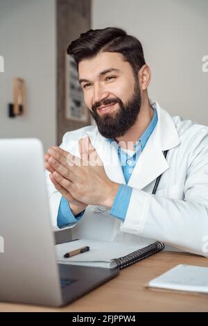 Smiling young caucasian grateful doctor using telehealth medical service Stock Photo