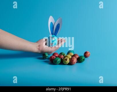 on the palm of your hand an egg with ears and Easter eggs Stock Photo