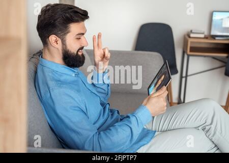 Millennial caucasian man having video call chat with young woman using tablet Stock Photo