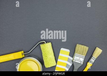tools for house improvement works. brushes, paint roller, paint can and color swatches on gray  background. top view Stock Photo