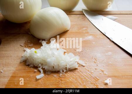 While preparing to make hamburgers, white onions are chopped with a chef's knife. Selective Focus onions. front view Stock Photo