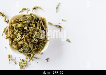 Dried mint leaves on a white background and in a white plate. Selective Focus Leaves Stock Photo