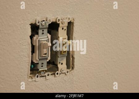 uncovered light switches in a white wall Stock Photo