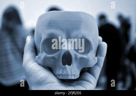 Skull printed on 3d printer in man's hand. Progressive modern Stock Photo