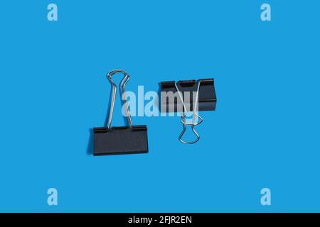 two paper clips on a blue background Stock Photo