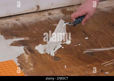 using a angled trowel to dollop cement on subflooring Stock Photo