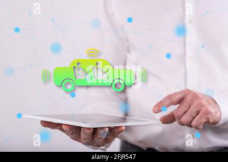 Autonomous vehicle concept above a tablet held by a man in background Stock Photo