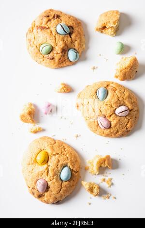 homemade cookies chocolate chips with colored candy eggs on a white background, top view. Stock Photo