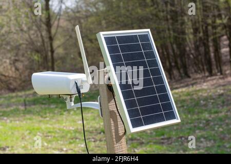 Surveillance camera with solar panel. Solar powered CCTV camera in remote rural location. Stock Photo