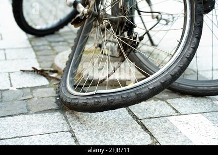 The bent rear tire of a bicycle in the city with destroyed chain. Stock Photo