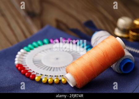 Threads and sewing accessories on brown wooden table Stock Photo