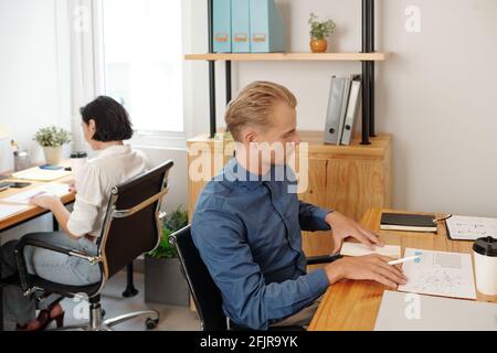 Business people working with charts and repots at tables in small office Stock Photo