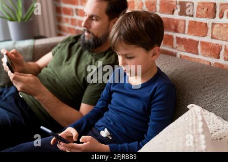 Close up of father and son using mobile phone Stock Photo