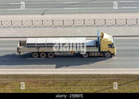 Truck with a fully loaded concrete block body with cement driving on the highway Stock Photo
