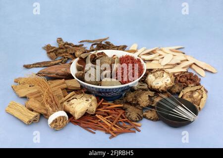 Chinese acupuncture needles with herbs & spice used in traditional herbal medicine & treatment  on mottled blue background. Alternative health care co Stock Photo