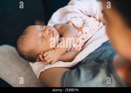 Upper view photo of a caucasian mother holding her newborn kid on hands napping Stock Photo